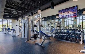 A gym with various exercise equipment, large windows, and a painting on the wall. - 9031srl Luxury 9beds Villas With Pool Spa In Solara (Kissimmee)