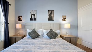 A neatly made bed with a patterned bedspread, two matching pillows, two bedside lamps, and three framed pictures on the wall. - 1576 Moon,champions Gate,4bed (Davenport)