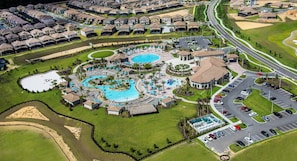 Zona residencial con una amplia piscina, varias canchas de tenis y un estacionamiento.