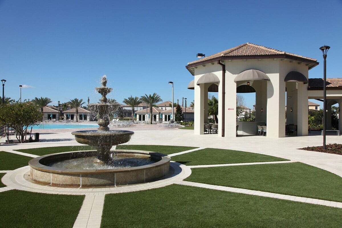 A fountain, a gazebo, and a pool in a landscaped area.
