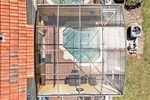 Una terrazza panoramica con struttura in vetro, una piscina e mobili da esterno.