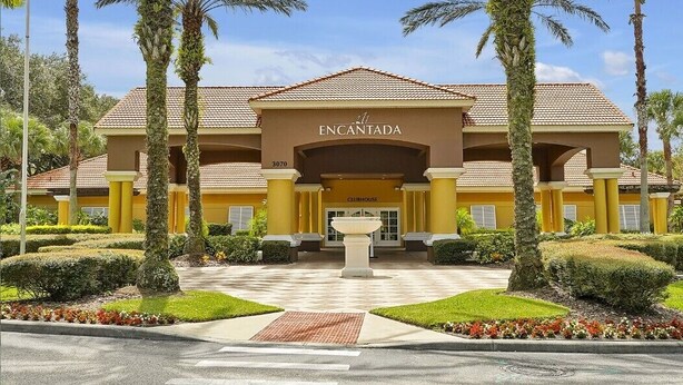 A hotel entrance with a sign reading "ENCANTADA CLUBHOUSE" and a number "3070" on the building. - 8567 BAY Lily Loop, 3 BED (Kissimmee)