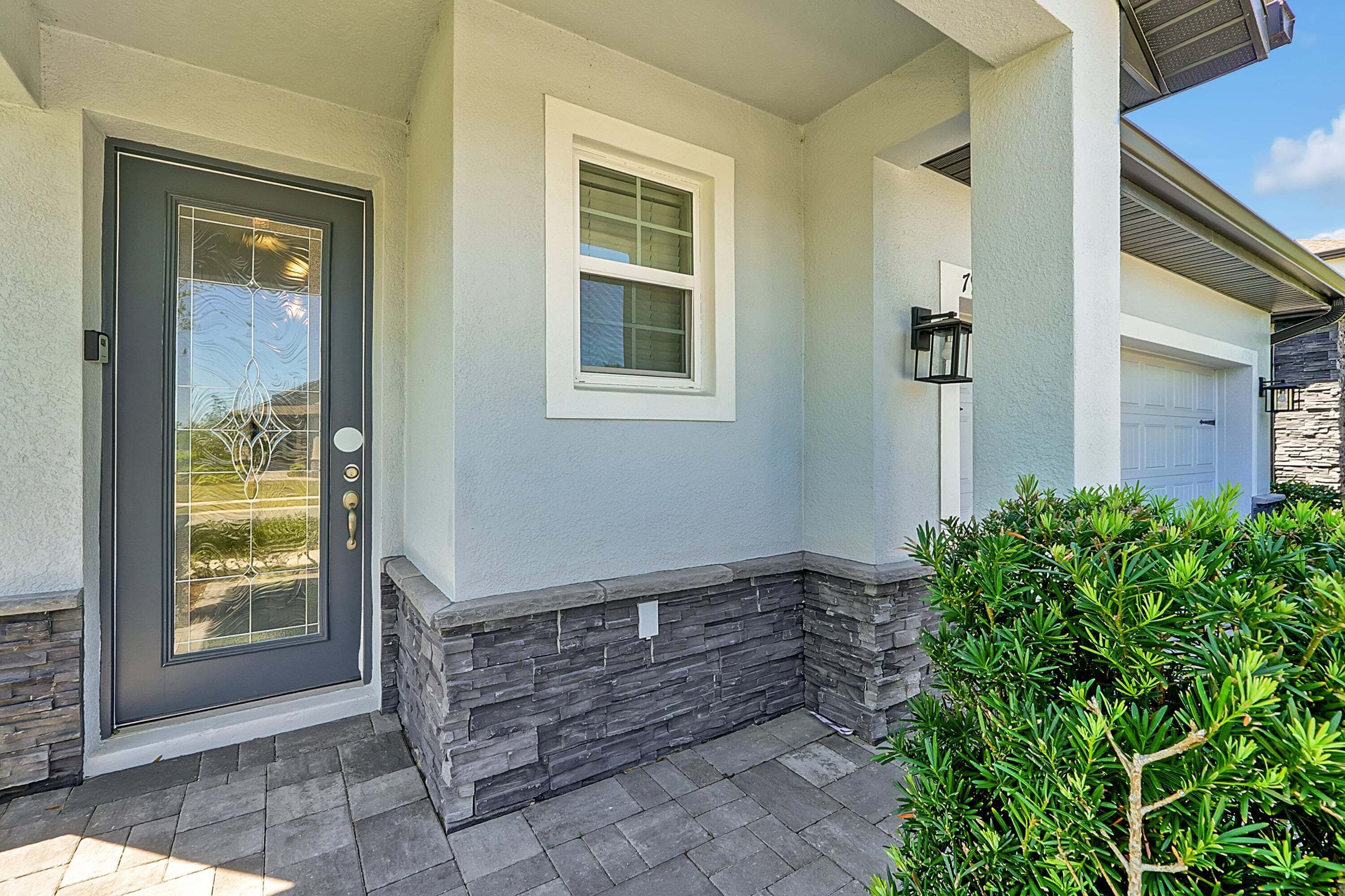 A house with a dark front door, a small window, and a garage door.
