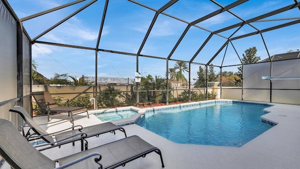 A covered outdoor swimming pool with lounge chairs and a view of the surrounding area. - Fp8176 Windsor Palms Resort Vacation Home (Kissimmee)