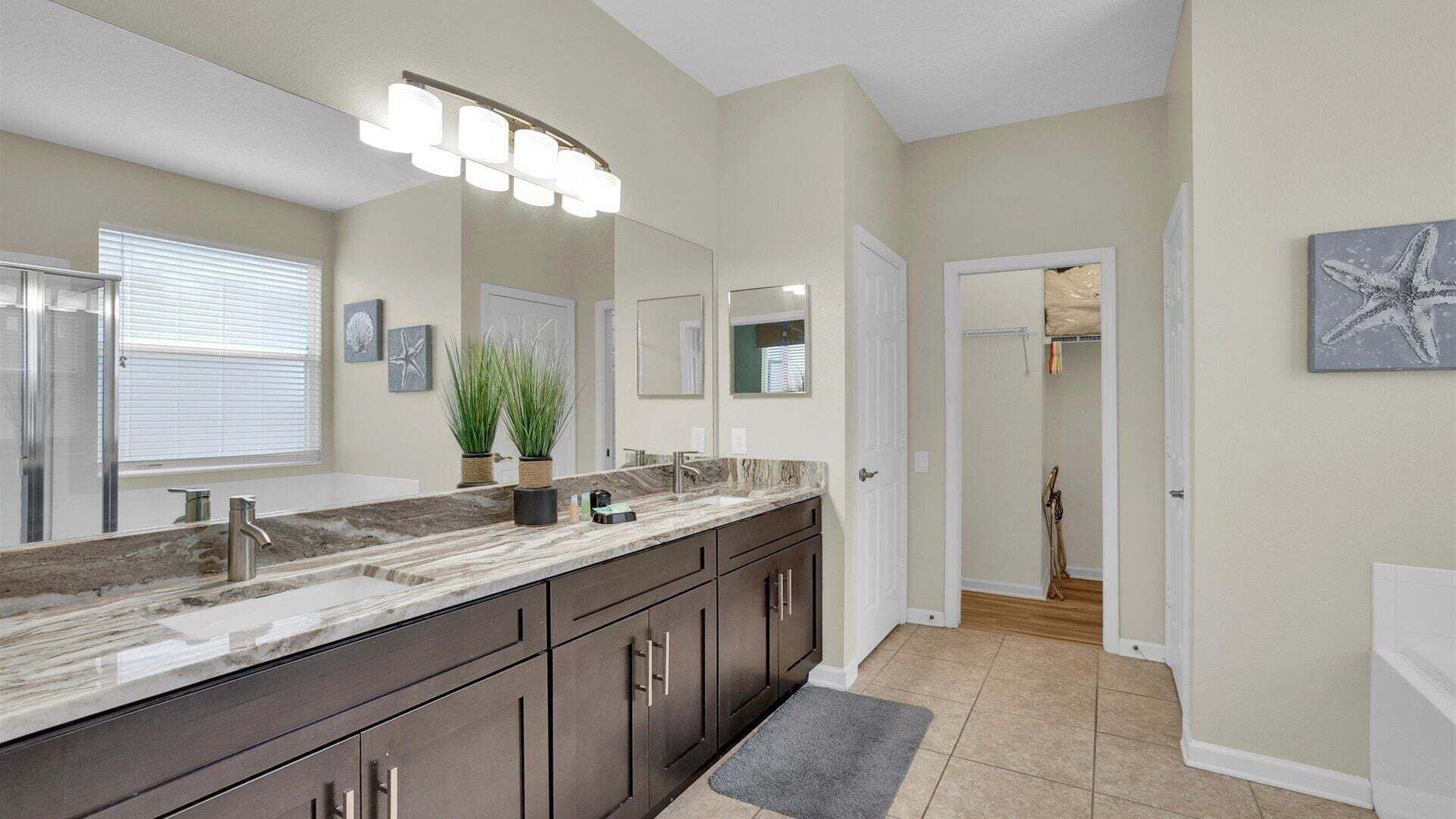 A bathroom with a large vanity, a shower, and a mirror.