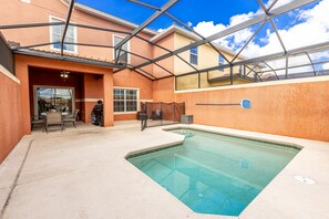 A swimming pool with a glass ceiling, a covered patio with chairs, and a view of neighboring buildings. - Flash 20 Off Spetacular Townhome With Private Pool Close to Disney 8919pp (Kissimmee)
