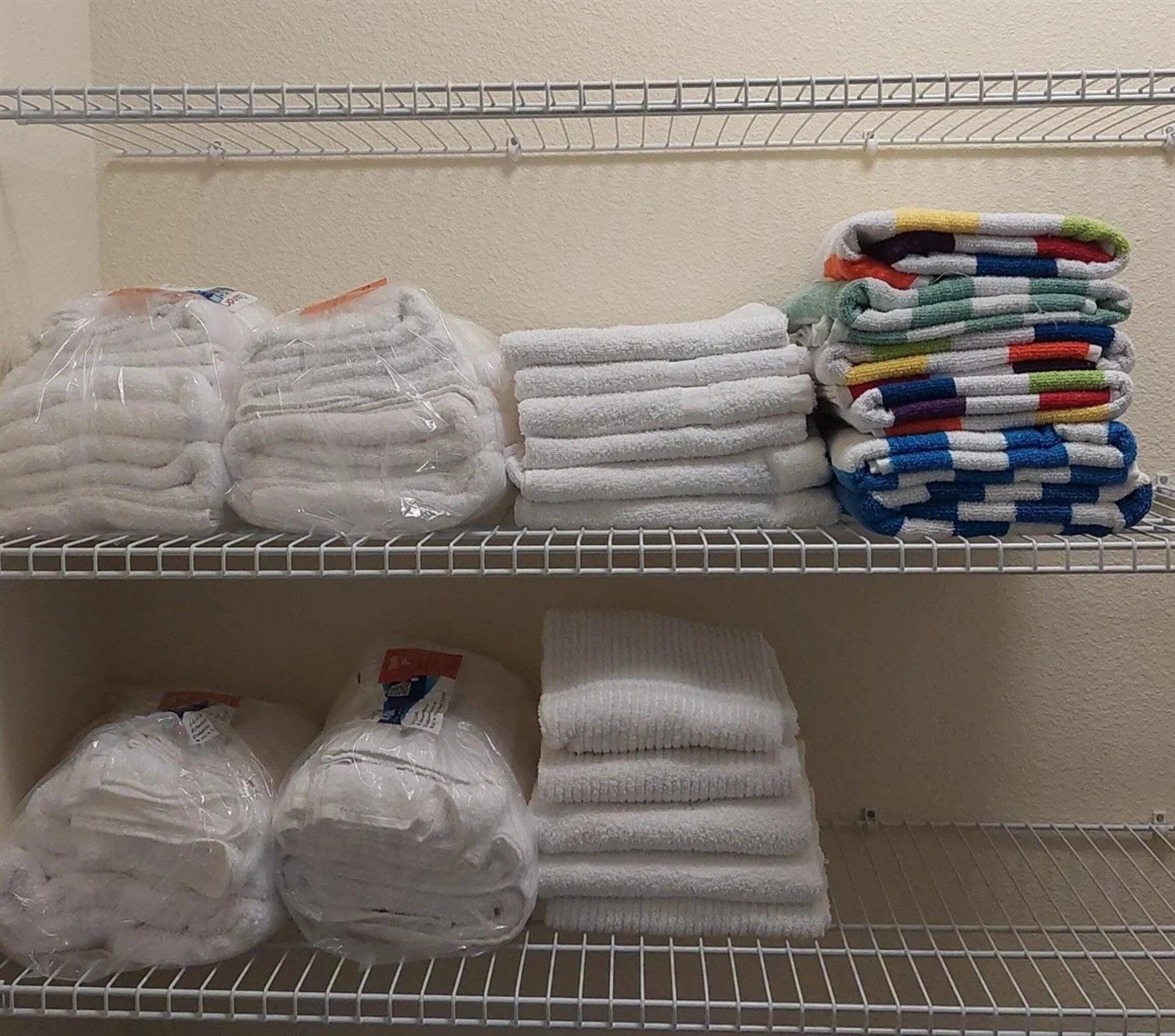 A storage area with shelves holding towels and bathrobes.
