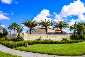 Un hotel con un cartello che riporta 'Windsor at Waterway', circondato da palme e un prato curato.