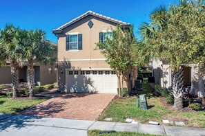 A two-story house with a garage, surrounded by palm trees and a brick driveway. - Flash 20 Off Private Pool Home at Windsor at Westside Resort (Kissimmee)