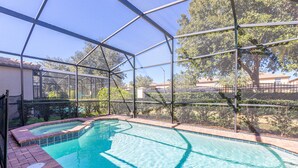 A swimming pool with a glass enclosure, surrounded by a brick deck and a metal fence. - Flash 20 Off Private Pool Home at Windsor at Westside Resort (Kissimmee)