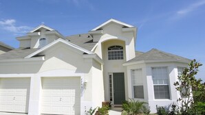 A two-story house with a garage, a small porch, and a large window. - Bnc7795 (Kissimmee)