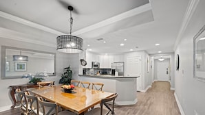 A modern kitchen with white cabinets, a central island, and stainless steel appliances. - Bk0203 Villas South Preserve (Kissimmee)