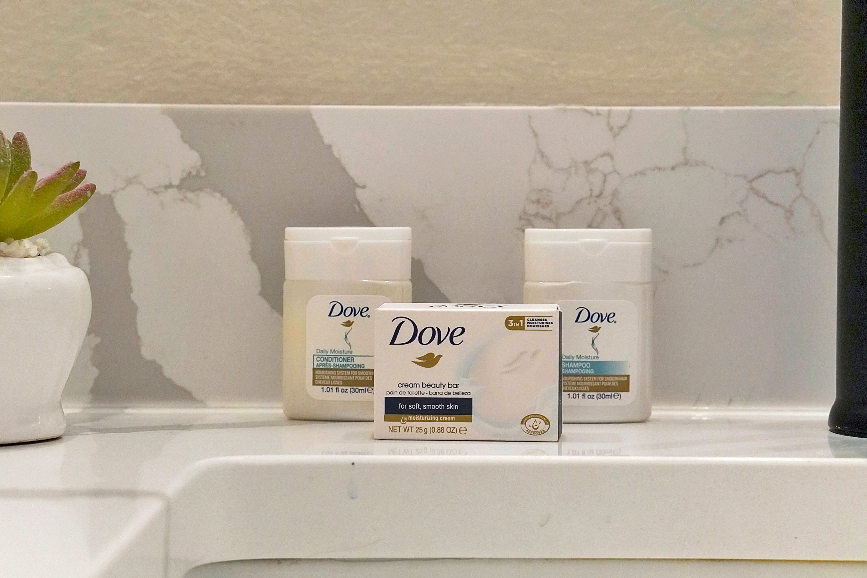 Dove cream beauty bar and shampoo products on a bathroom shelf.