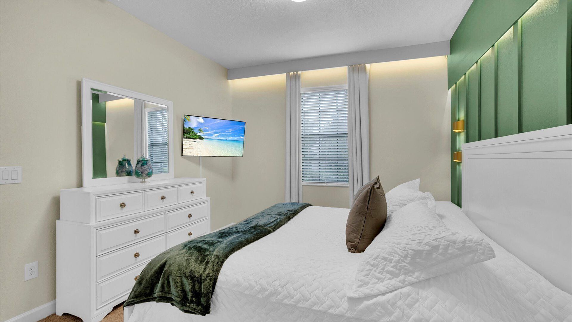 Un dormitorio con cama, cómoda, televisor y ventana con persianas.