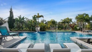 A swimming pool with lounge chairs, palm trees, and a statue. - Sg148t Eagle Cove (Kissimmee)