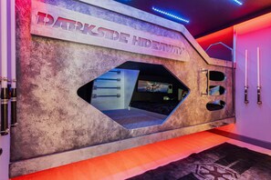 A room with a large window, a sign reading 'DARKSTED HIDEAWAY,' and a wall-mounted weapon rack. - Rc164p Fairway Fun Castle (Kissimmee)