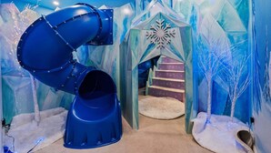 A play area with a spiral slide, a snowflake decoration, and a staircase leading to a small enclosed space. - Rc164p Fairway Fun Castle (Kissimmee)