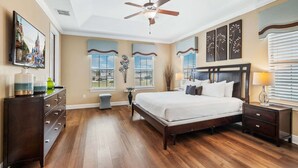 A bedroom with a large bed, a ceiling fan, a nightstand, a dresser, and a window with blinds. - Rc164p Fairway Fun Castle (Kissimmee)