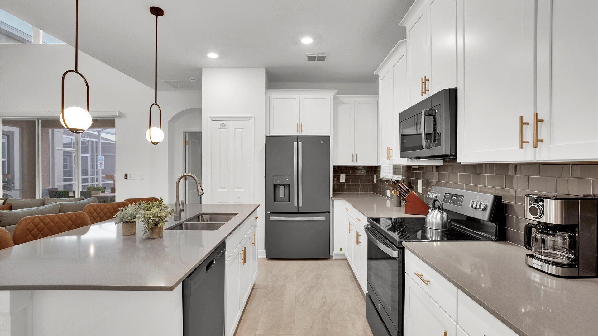 A modern kitchen with white cabinets, stainless steel appliances, and a central island.