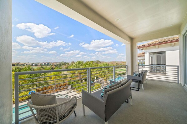 Un balcon agrémenté de mobilier d’extérieur, une vue dégagée sur le paysage et un toit recouvert de tuiles.