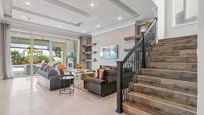A spacious living area with a staircase, a sofa, a coffee table, and a dining table. - Qj068n Enchantment at Bear's Den (Kissimmee)