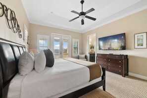 A bedroom with a bed, a ceiling fan, a dresser, and a television. - Rd989m Fairway Haven (Kissimmee)