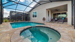 Piscina con jacuzzi, rodeada por un patio techado con sillas y ventilador de techo.