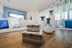 A living room with a wooden coffee table, a sofa with blue cushions, and decorative vases. - Tsd4711 (Davenport)