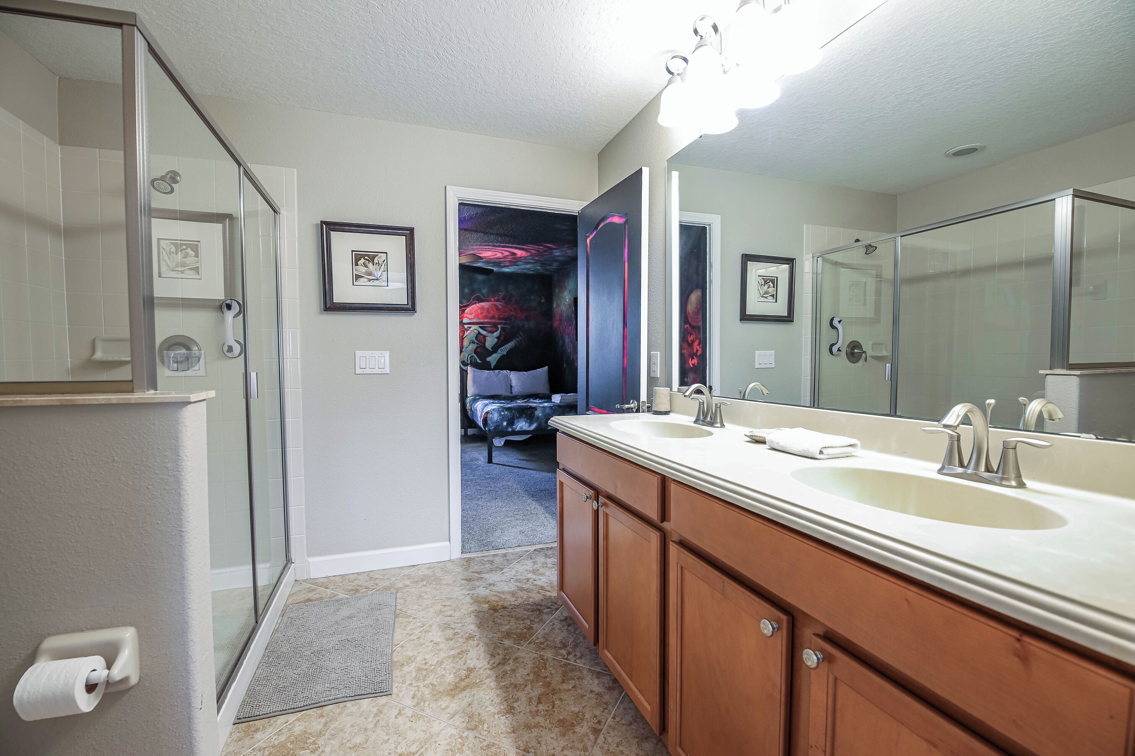 A bathroom with a double sink, a large mirror, and a shower area.