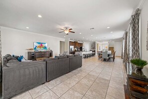 A spacious living area with a sectional sofa, a ceiling fan, recessed lighting, a dining area, and a kitchen in the background. - Tg220t Heritage Rock Spring (Kissimmee)