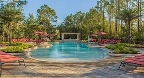 A pool area with red lounge chairs and umbrellas, surrounded by trees. - Tvpm-8079br/fcg (Davenport)