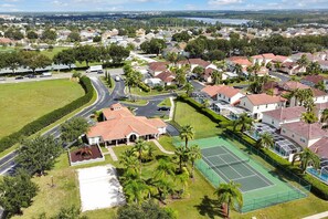 Un quartiere residenziale con case, un campo da tennis e una strada.
