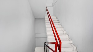 A staircase with white steps and a red handrail. - Hotel O near Ring Road City Walks (Medan)