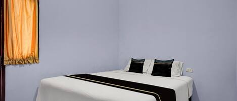A bedroom with a bed, a curtain, and a patterned ceiling.