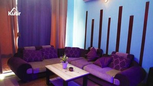 Una sala de estar moderna con un conjunto de sofá, una mesa de centro y una planta en maceta.