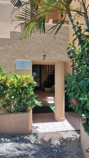 Ein Gebäudeeingang mit einem Schild, auf dem 'Oceanfront Dream Coral Sands 07' steht.