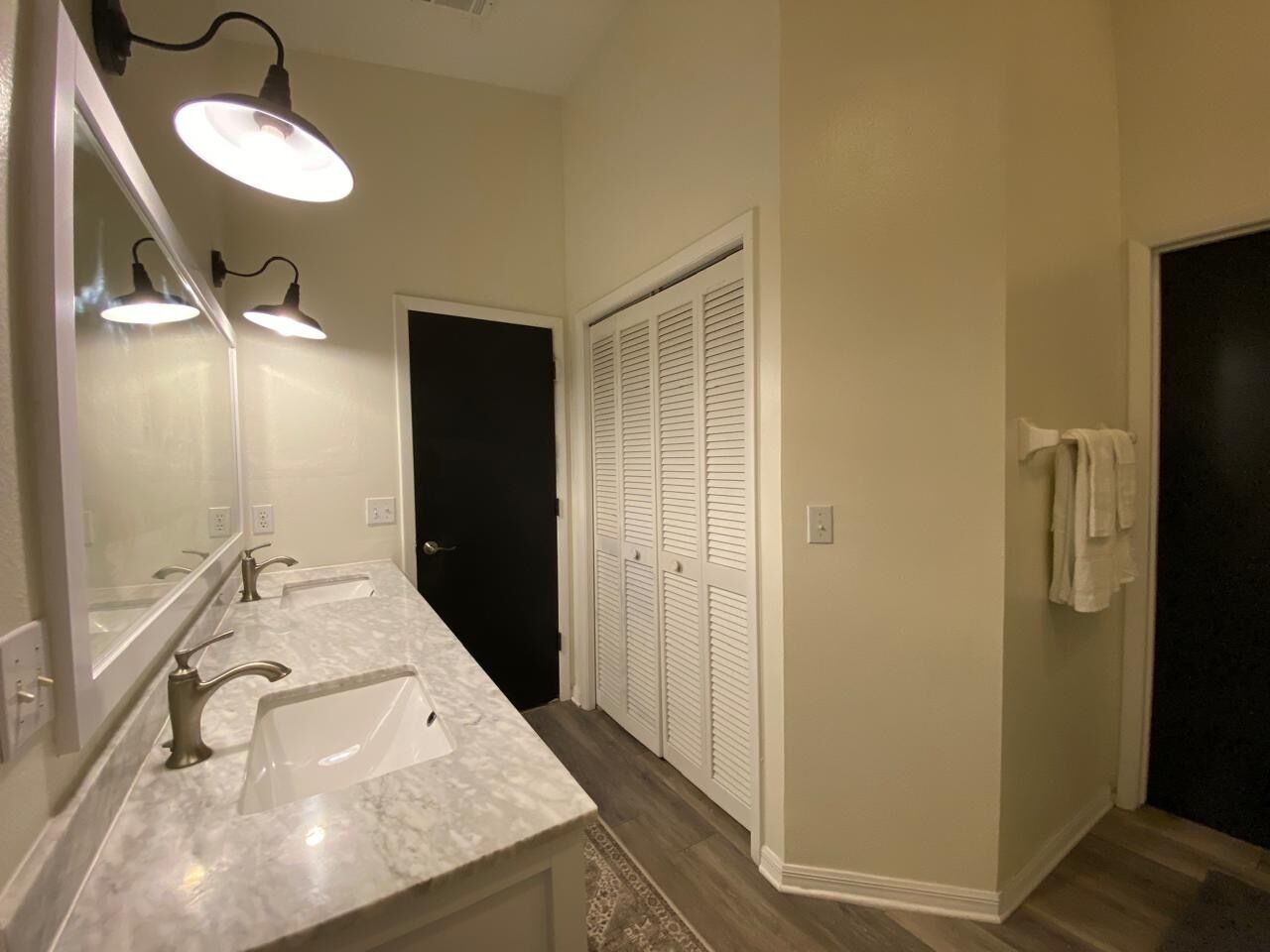 Un baño con dos lavamanos, un espejo y un vestidor.