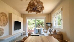 Un soggiorno moderno con un tavolo da pranzo in legno, un divano e una TV a parete.