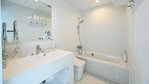 A modern bathroom with a white sink, mirror, and shower.