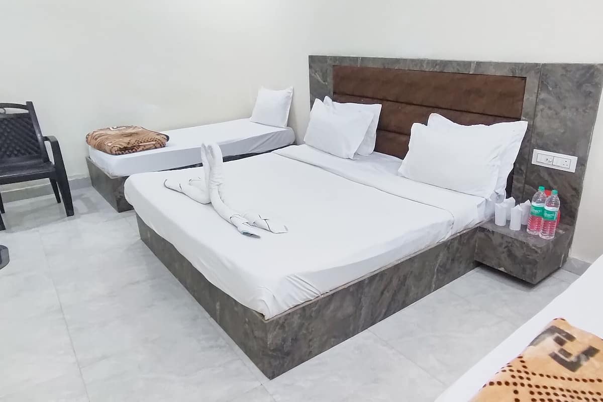 Une chambre d’hôtel avec deux lits, une chaise et une petite table.