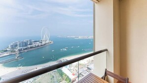 En balkon med udsigt over kystlandskab, inklusive et stort pariserhjul og moderne bygninger.