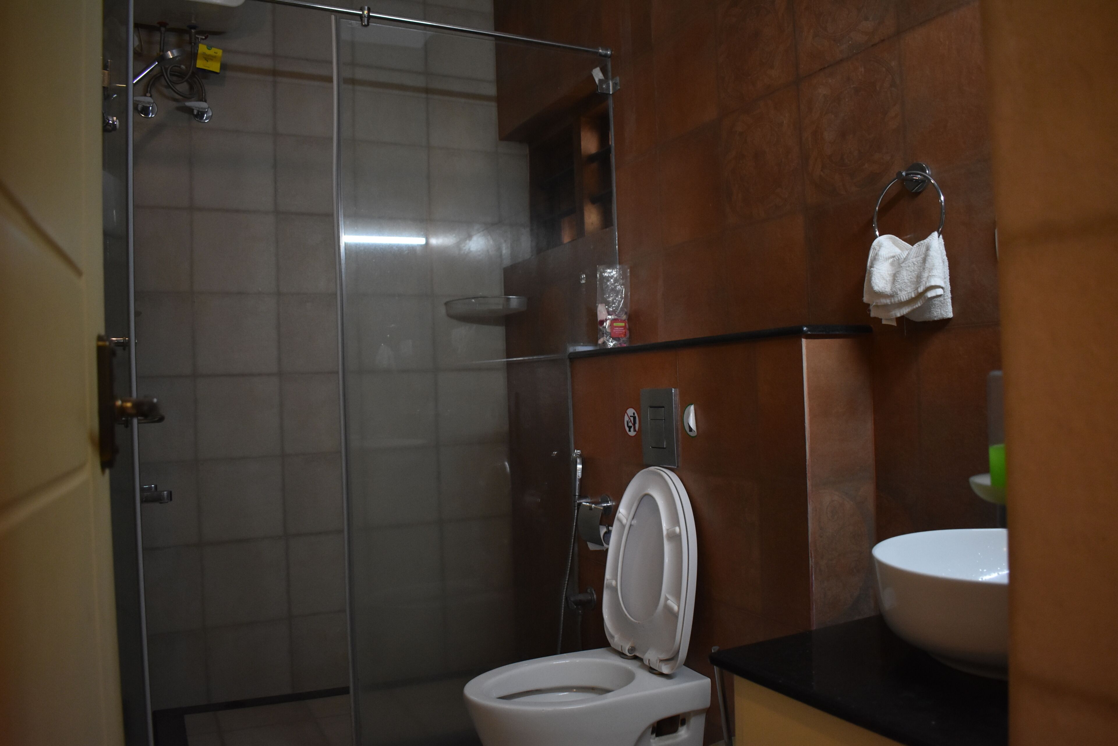 Un baño con cabina de ducha de vidrio, inodoro blanco y lavabo con espejo.