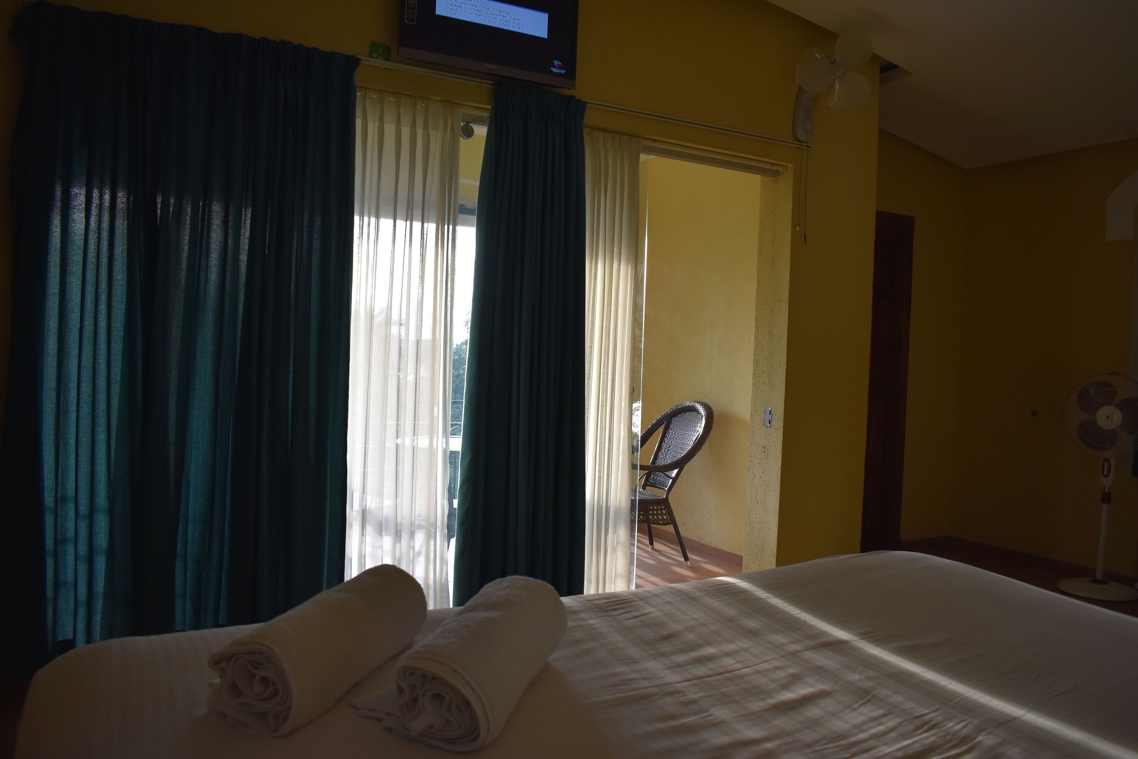 Una habitación de hotel con una cama, una silla y un televisor.