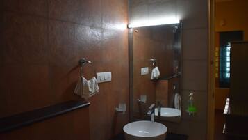 A bathroom with a sink, mirror, towel rack, and soap dispenser.