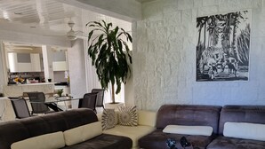 Ein modernes Wohnzimmer mit zwei Sofas, einem Couchtisch und einer großen Pflanze.