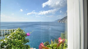 Un balcón con vistas al mar y montañas lejanas.