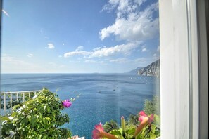 Ein Balkon mit Blick auf das Meer und ferne Berge.