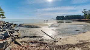 A beach with a wooden pier extending into calm waters, surrounded by trees and rocks. - Potomac River Haven w/ Private Beach, Dogs Welcome (Hague)
