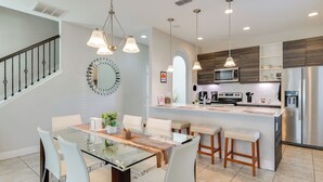 A modern kitchen with a central island, stainless steel appliances, and pendant lighting. - Golf, Dine & Unwind Poolside! Haines City Getaway (Haines City)