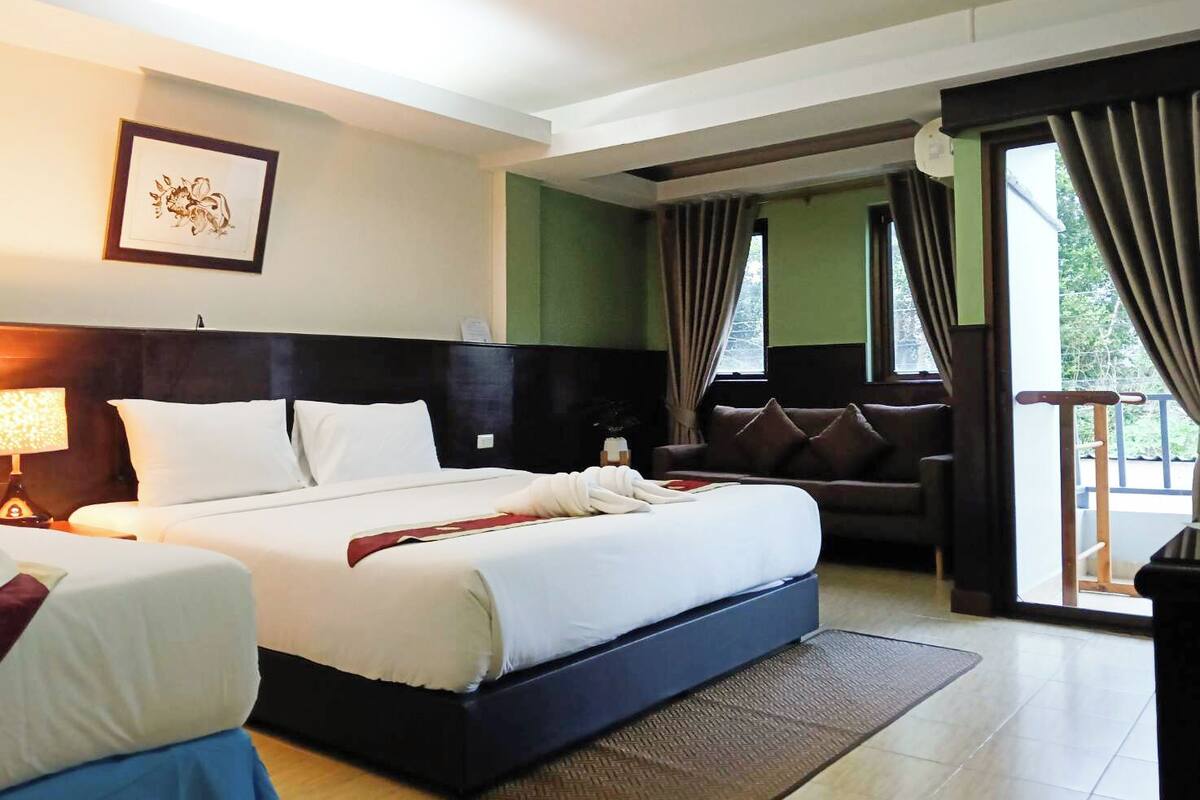 Une chambre d’hôtel avec un grand lit, un canapé et une vue sur l’extérieur.